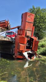 Akcja ratownicza w Starych Kolniach: kombajn wpadł do rzeki Stobrawa