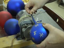 Przygotowanie bombki wymaga sporo ręcznej pracy - od wydmuchania szkła przez srebrzenie i zdobienie aż do obcięcia oraz pakowania.