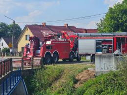 Akcja ratownicza w Starych Kolniach: kombajn wpadł do rzeki Stobrawa