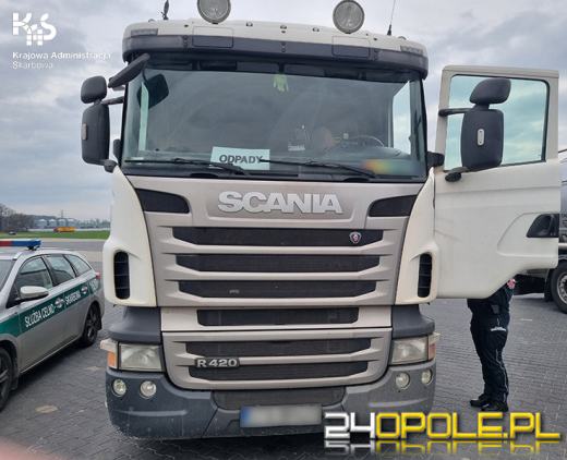 Samochód ciężarowy przewożący odpady oznakowany kartką za szybą 